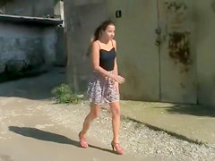 Coward young lady pees on an outdoor walk